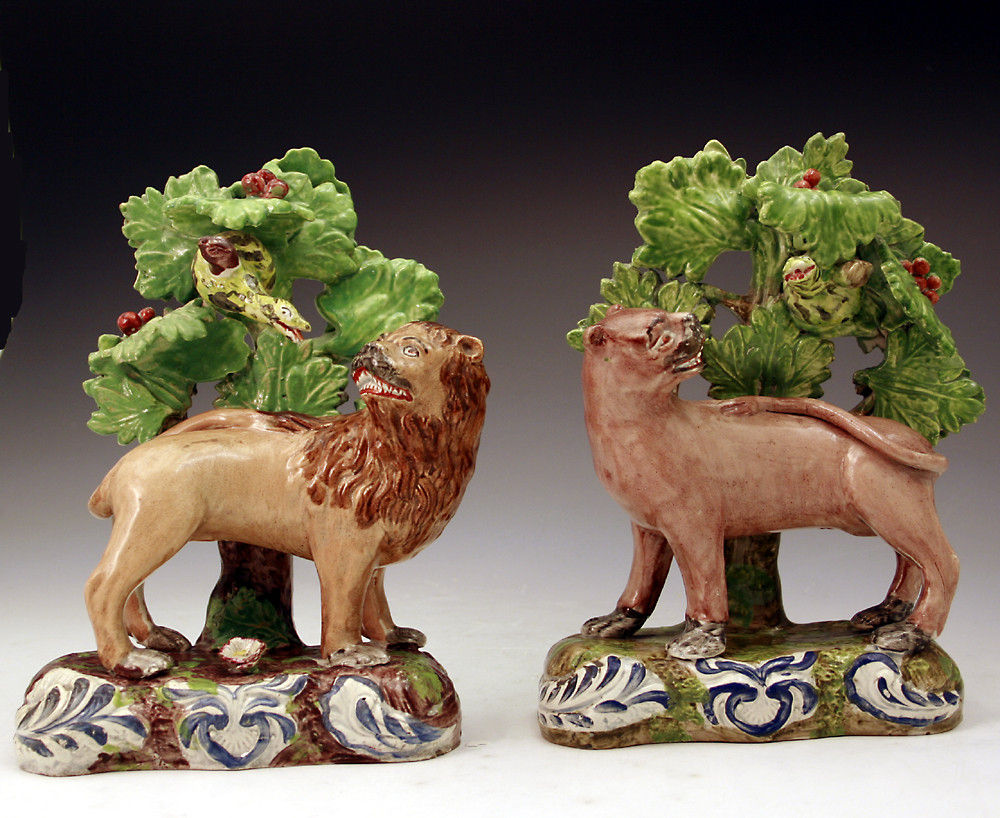 Pair of Staffordshire pottery figures of a lion and lioness against bocage