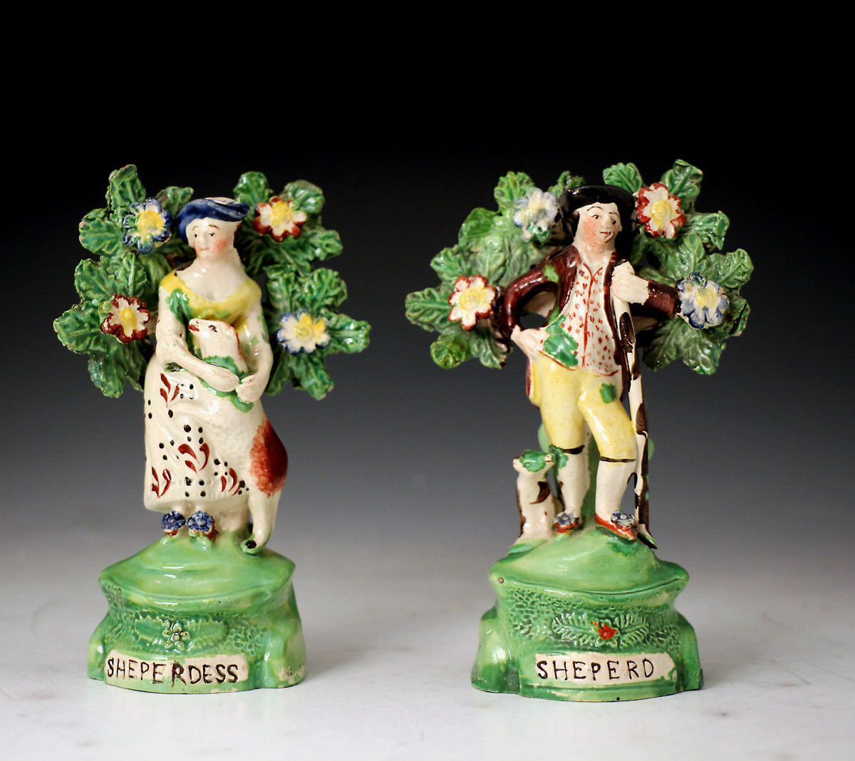 Staffordshire pottery figures of a shepherd and shepherdess with bocage c1820