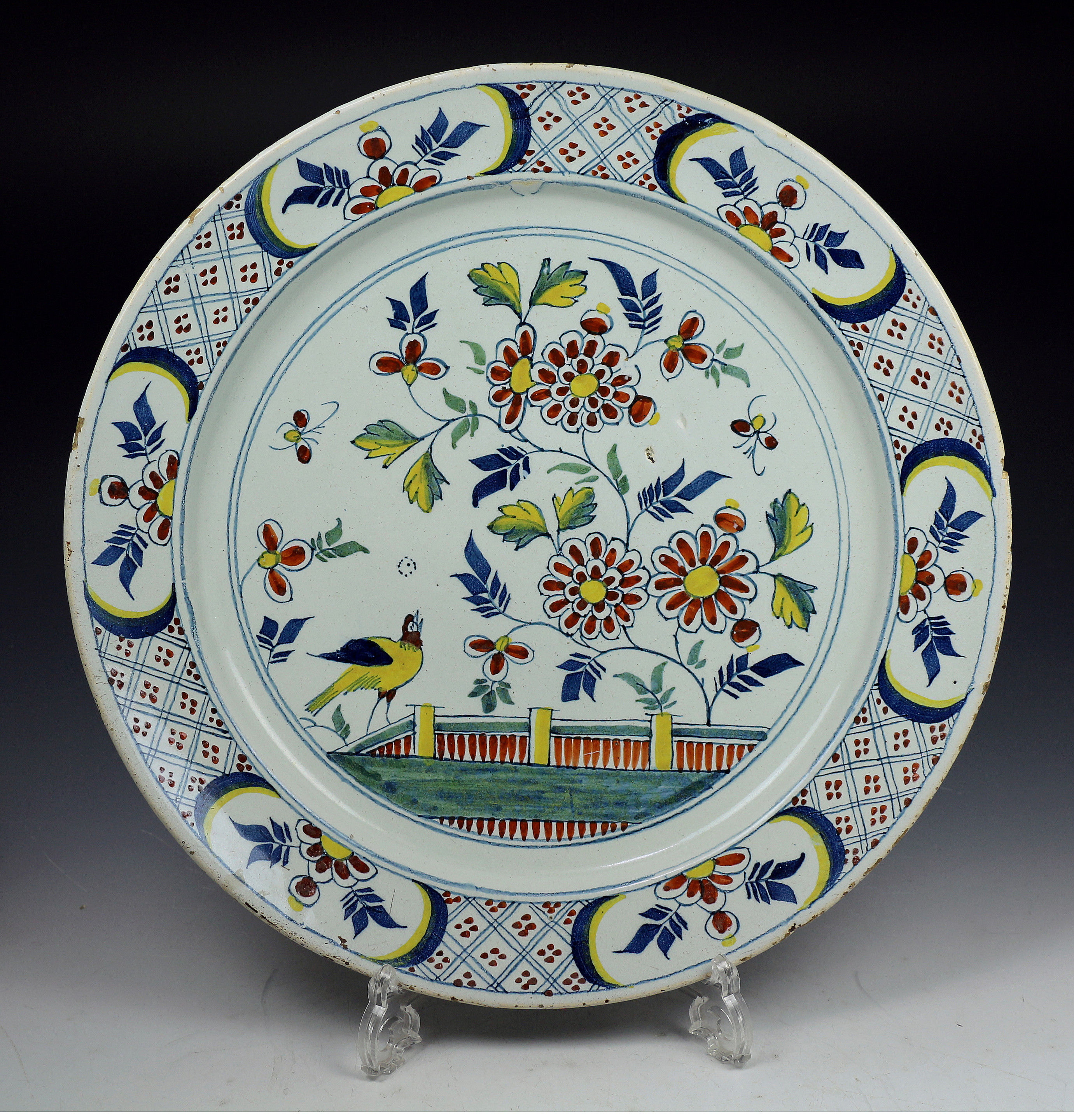 English delftware pottery charger in polychrome colours c1730