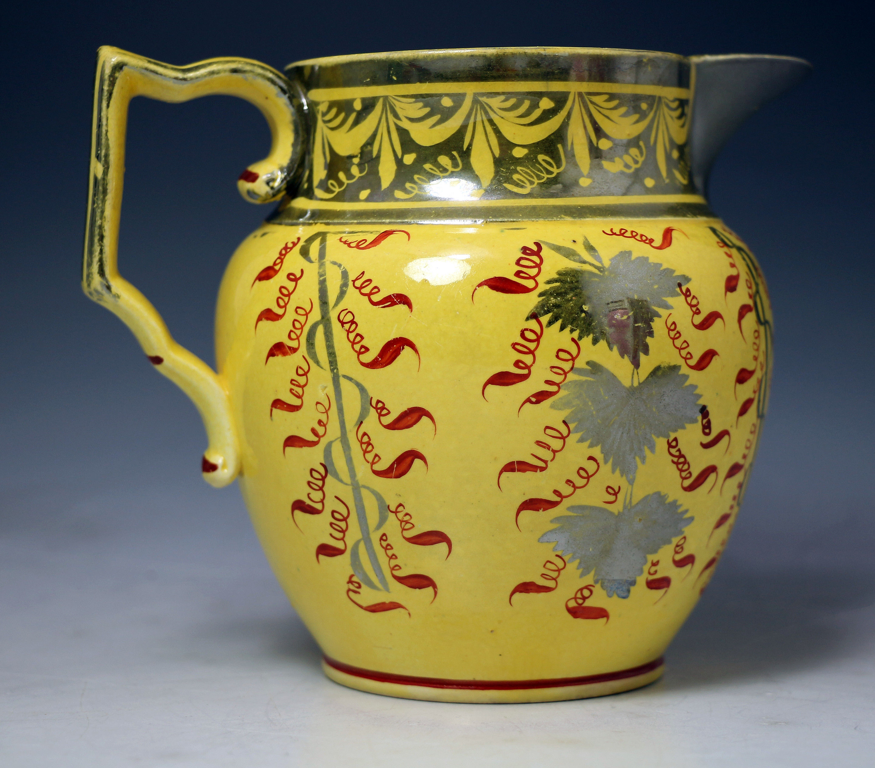 English pottery antique pitcher with canary yellow ground and silver luster decorations.