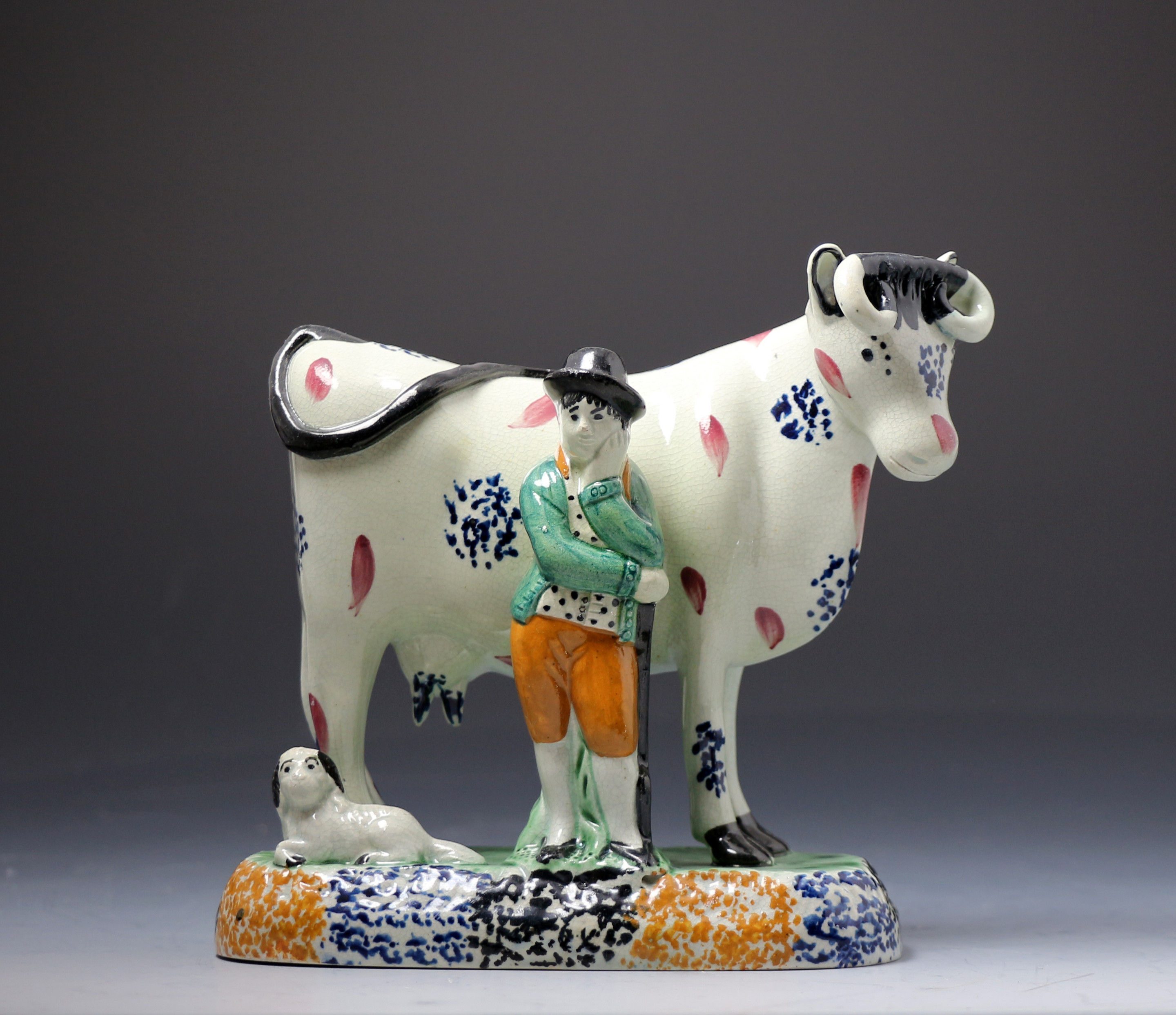 Antique Yorkshire pottery figure of a cow with farm hand in Pratt colours.