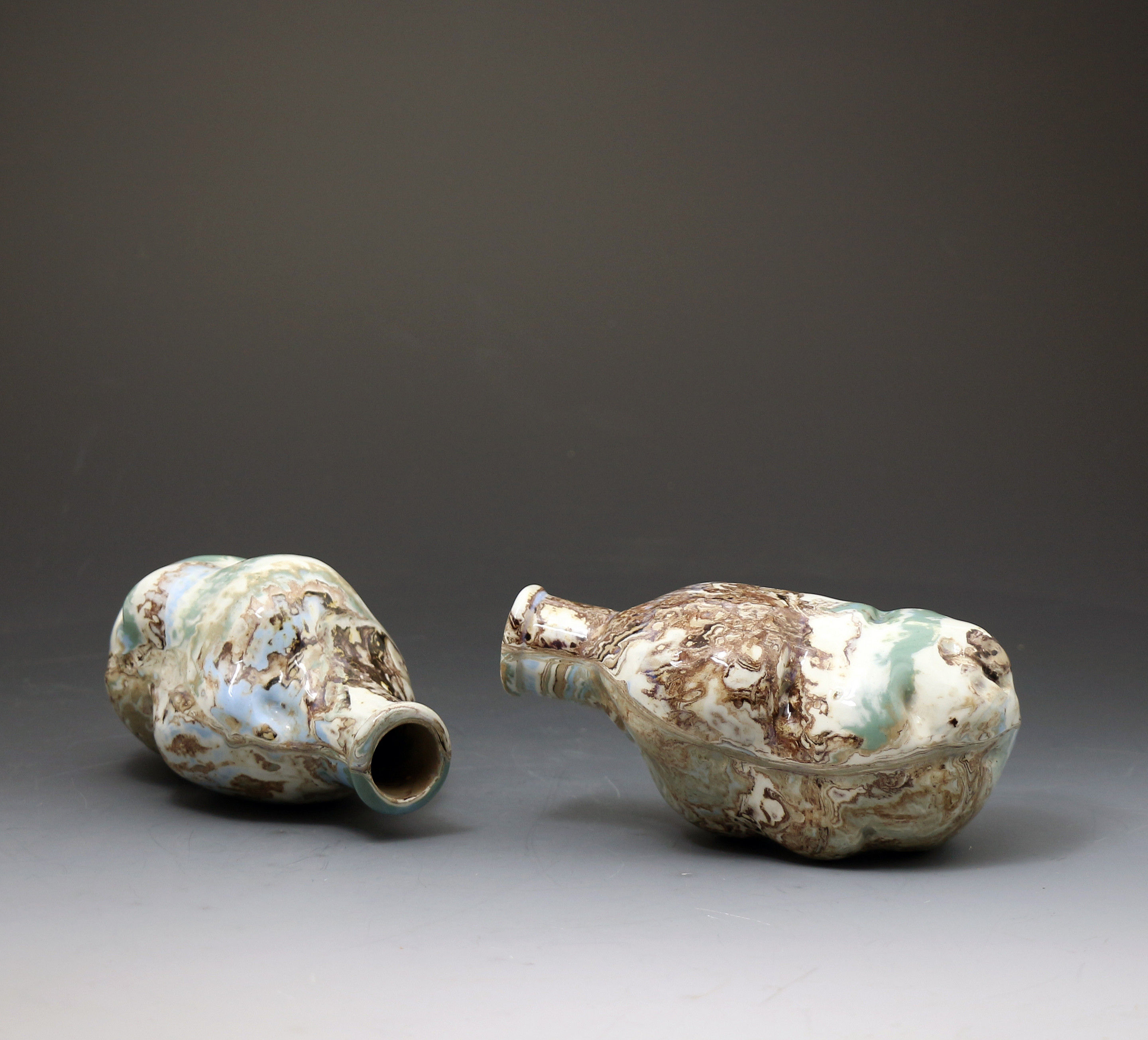 Pair of antique surface decorated agate ware pottery spirit flasks with mocha colors.