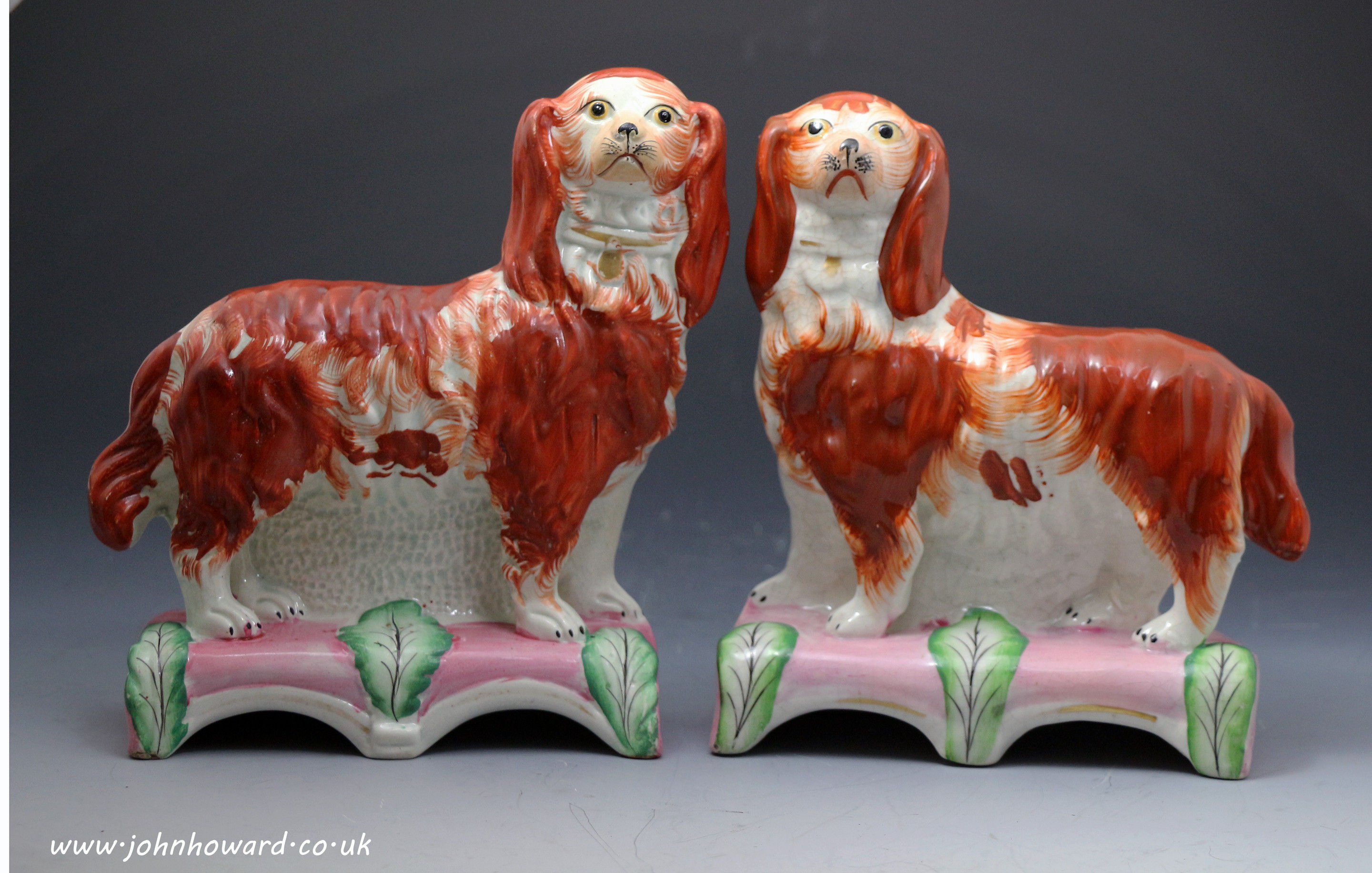 Antique Staffordshire figures of spaniels standing on pink and green bases known as Grace and Majesty c1855