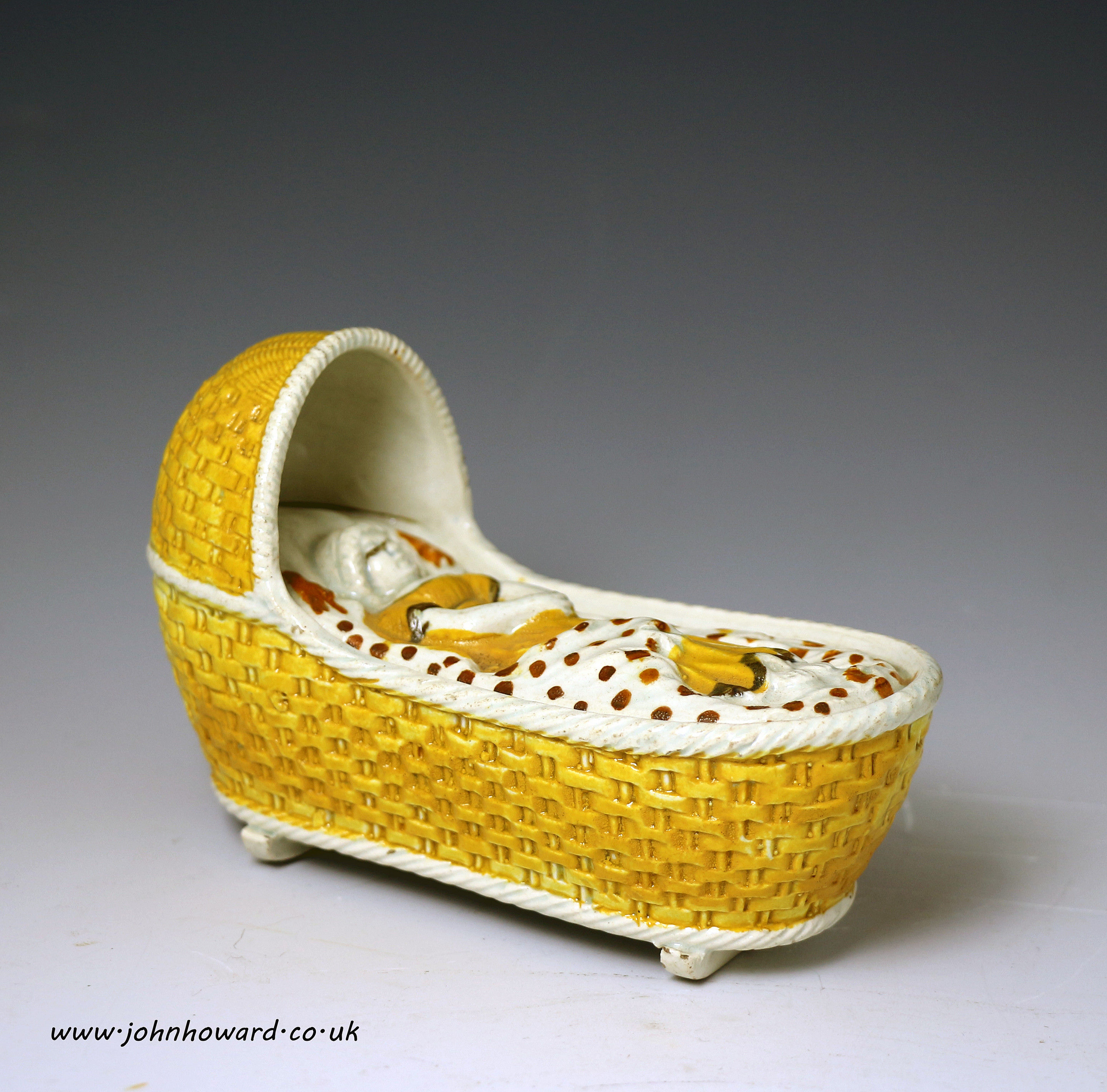 Prattware pottery baby in cradle early 19th century .