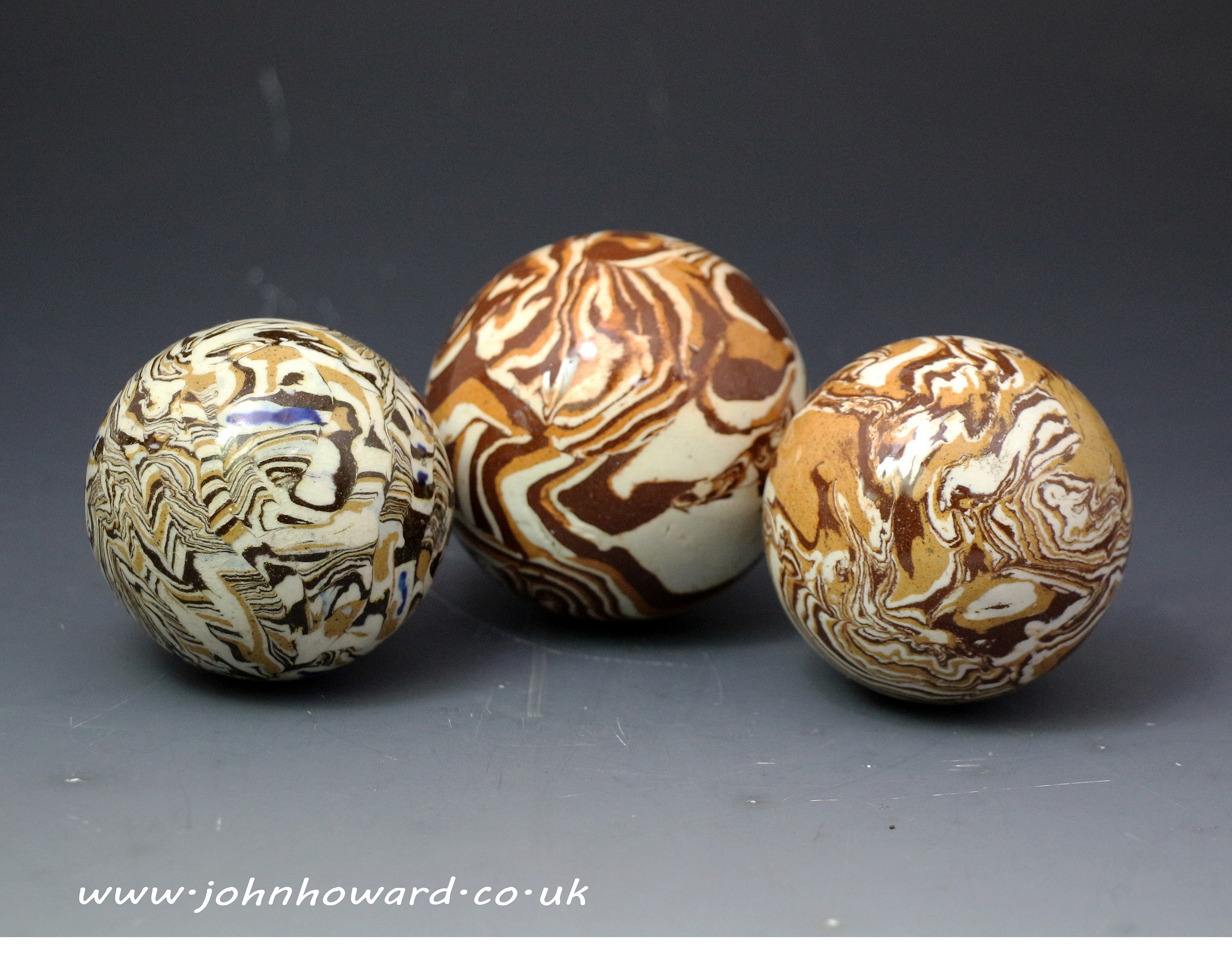 Three antique English pottery agateware balls late 18th century