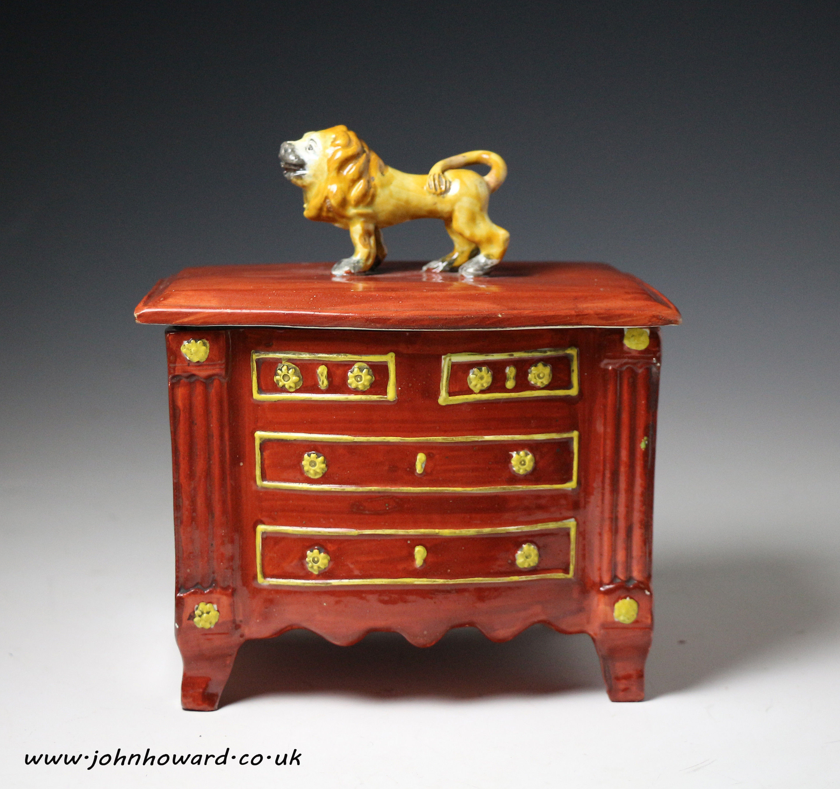 Staffordshire pottery pearlware box in the form of a chest of drawers with lion finial on cover, early 19th century period.