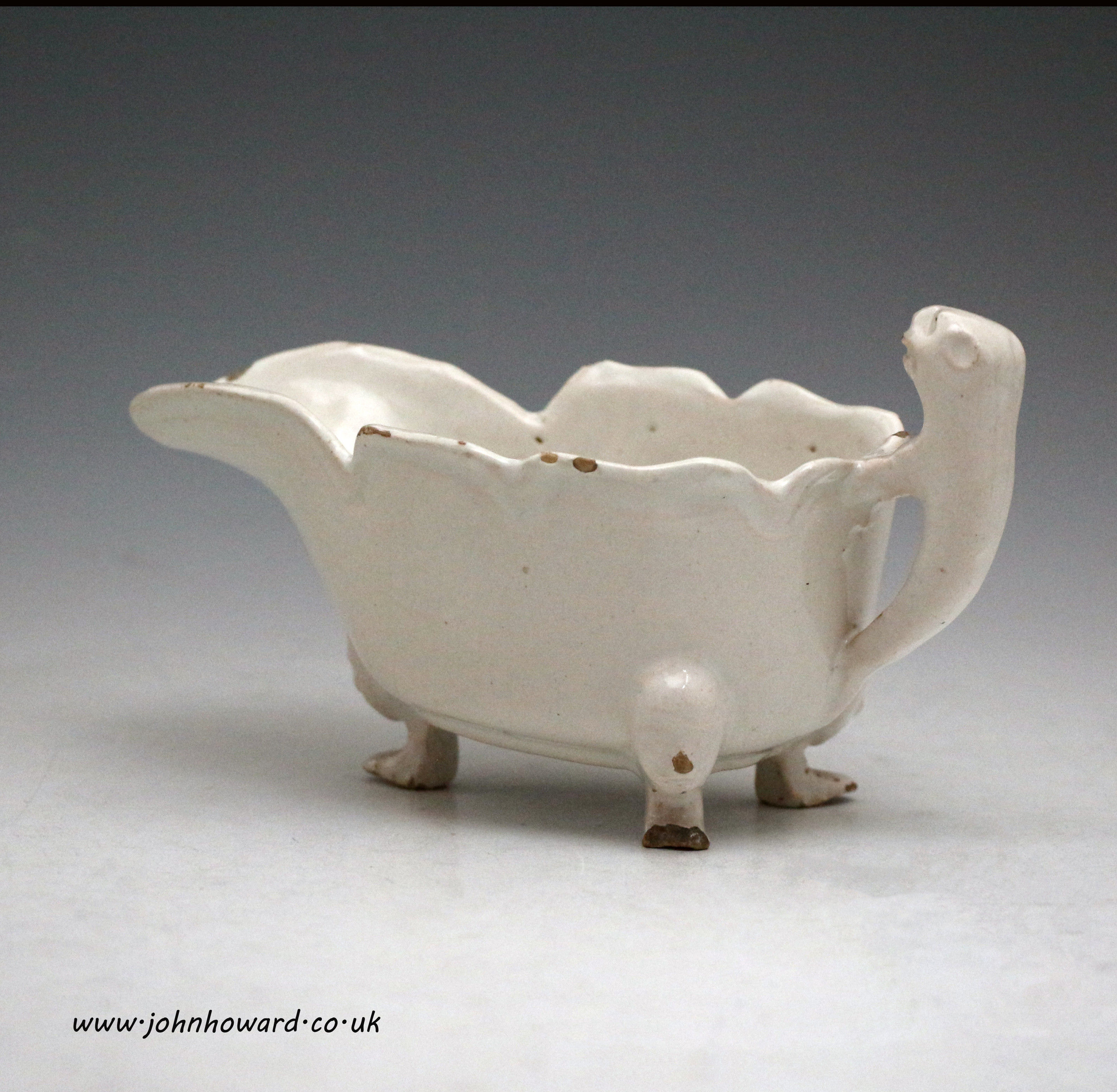 English delftware pottery sauce boat with three feet and lion form handle. mid 18thc.