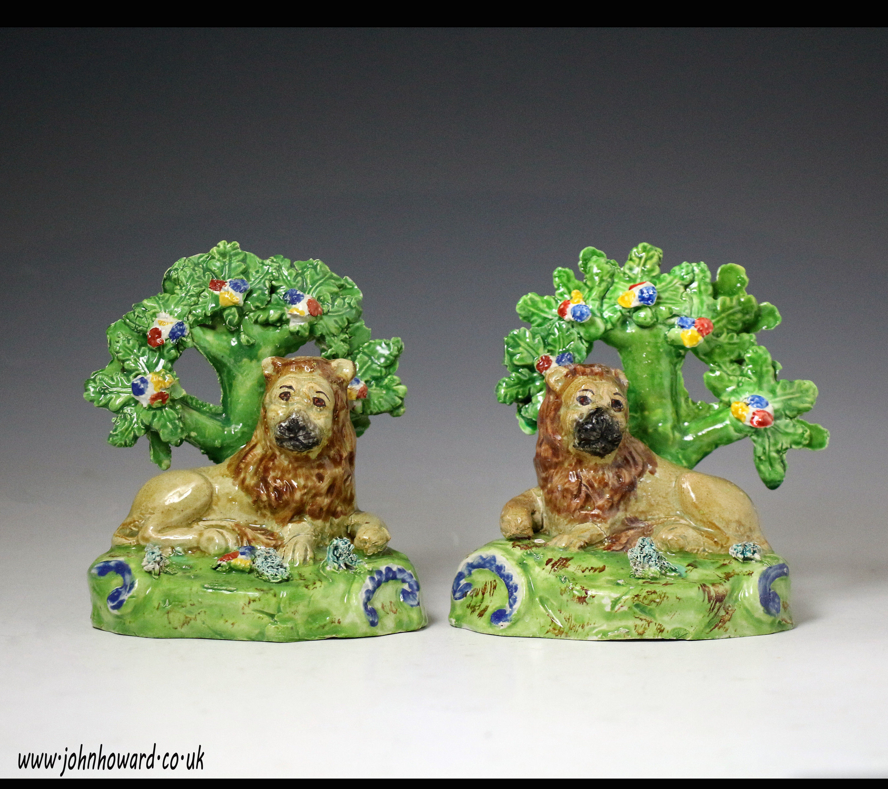 Pair antique Staffordshire pottery figures of lions with bocage marked Walton. early 19th century