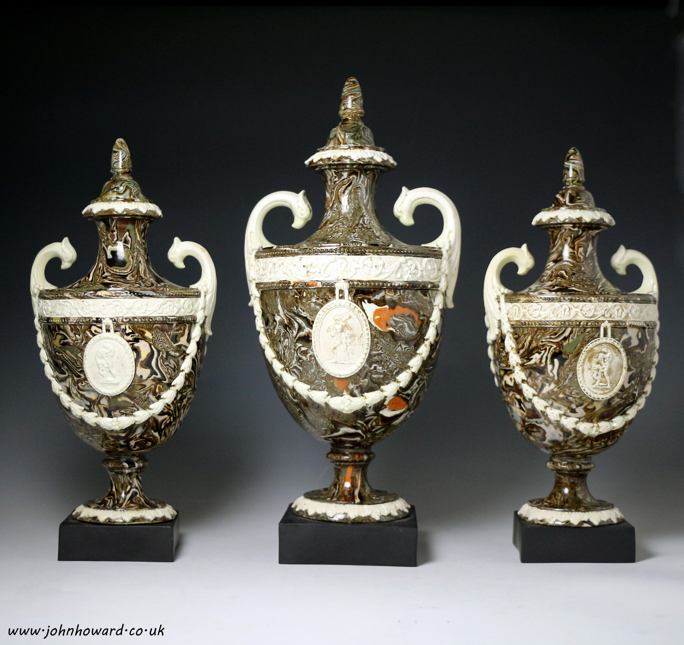 Agateware creamware pottery garniture of classical vases with covers standing on basalt bases with  impress mark I Neale  Hanley 
