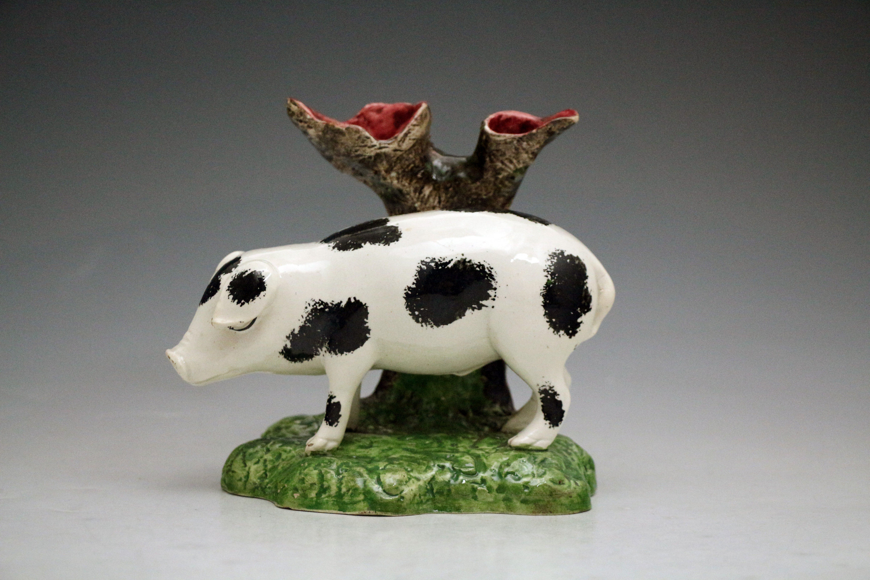 Antique pottery figure of a pig standing by tree trunk. Scottish early 19th century