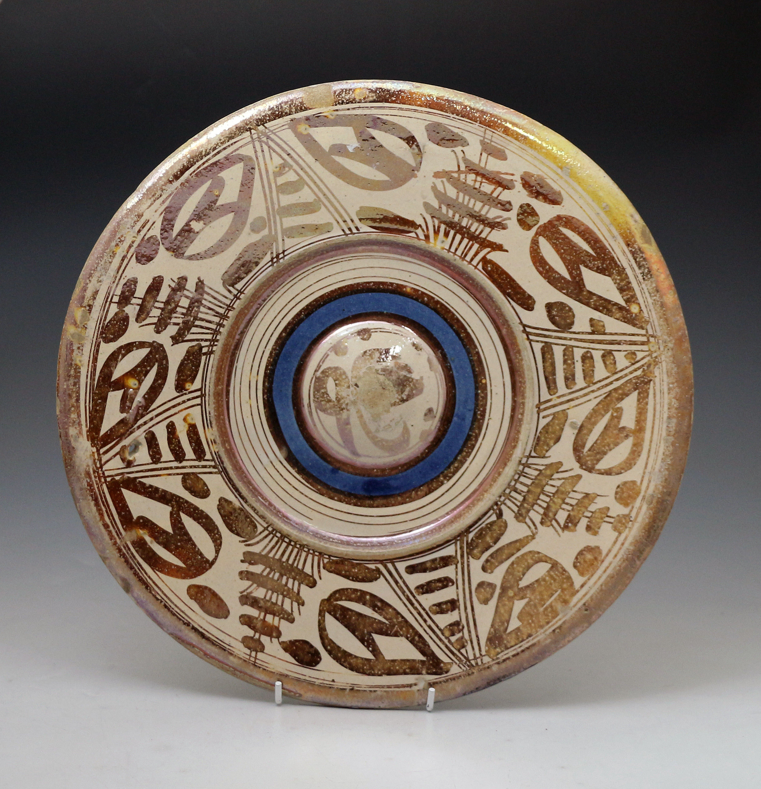 Early Hispano Moreque pottery charger decoarted with pink lustre and a blue band. C1650